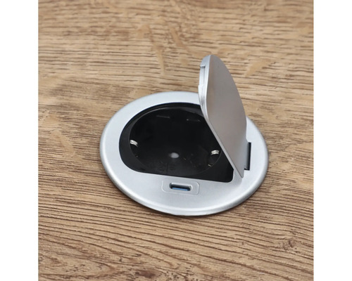 Runt golvuttag med öppet lock på trägolv