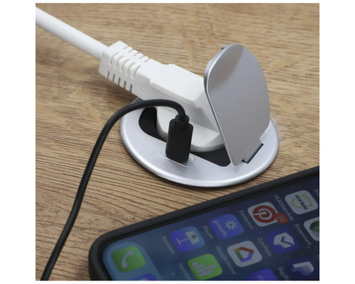 Bordsuttag med USB-port och strömkabel på ett bord