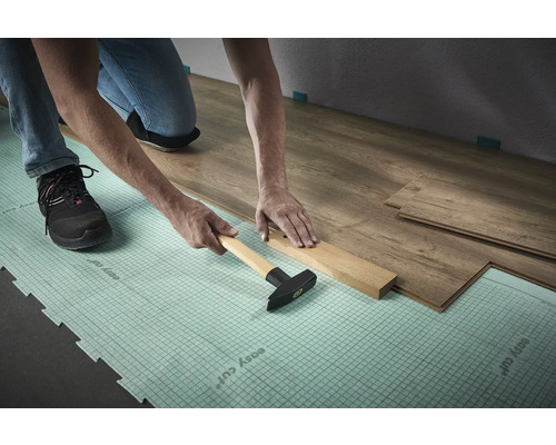 Läggning av laminat med hammare och slagkloss på isolerande underlag