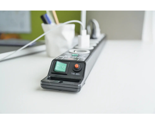 Grenuttag med strömbrytare och överbelastningsskydd på ett bord.