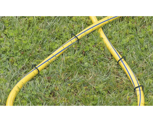 Gul trädgårdsslang med slanghållare i gräset