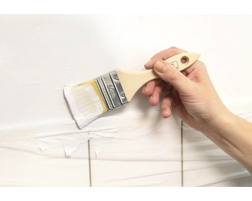 Hand målar kakelvägg med pensel