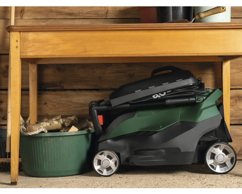 Hopfälld gräsklippare under ett bord