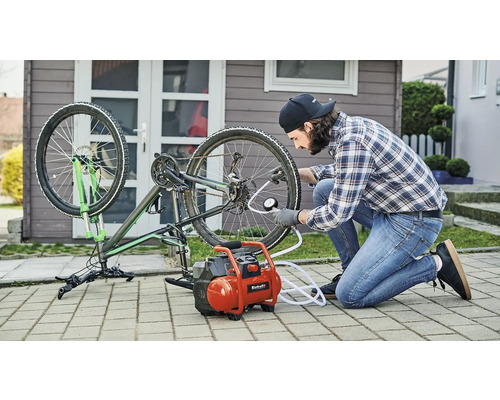 Man pumpar cykeldäck med en kompressor