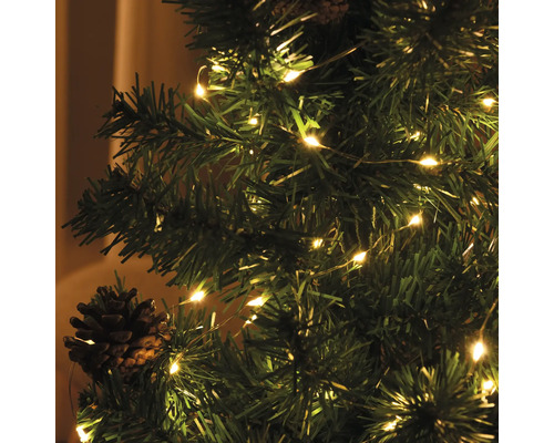 Julgran dekorerad med ljusslinga och kottar