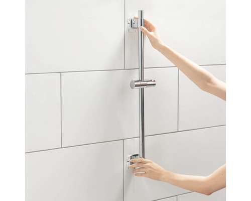 Duschstång i metall monteras på en kakelvägg.