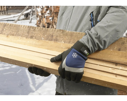 Person som bär arbetshandskar och håller träplankor