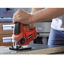 En person använder en Einhell sticksåg för att skära en arbetsstycke