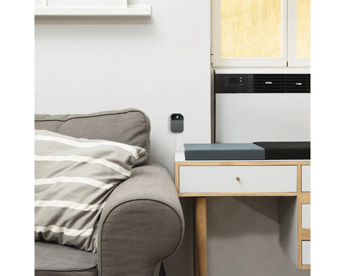 Grå övervakningskamera monterad på en vit vägg