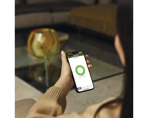 Kvinna håller en smarttelefon med säkerhetsapplikation i handen