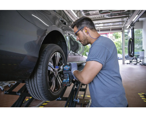 En mekaniker byter ett hjul med en sladdlös mutterdragare.