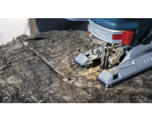 Närbild av en sticksåg som skär isoleringsmaterial.