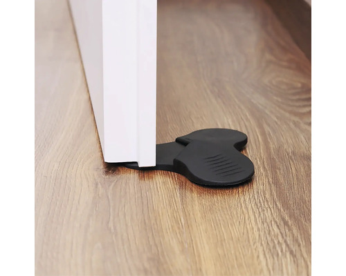 Svart dörrstopp av gummi säkrar en dörr.