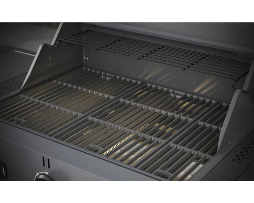 Insidan av en gasolgrill med grillgaller och värmehylla.