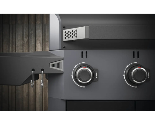 Närbild av en kolgrill med vridknappar för temperaturkontroll