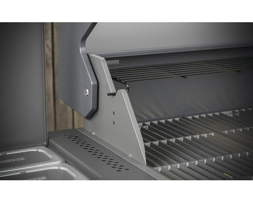 Detaljvy av en öppen gasolgrill med grillgaller och varmhållningsgaller