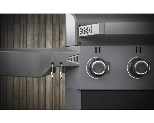 Detaljvy av en kolgrill med vridknappar och förvaringsutrymme