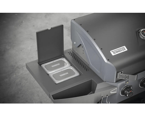 Detaljvy av en gasolgrill med öppen varmhållningshylla och Tenneker-logotypen.