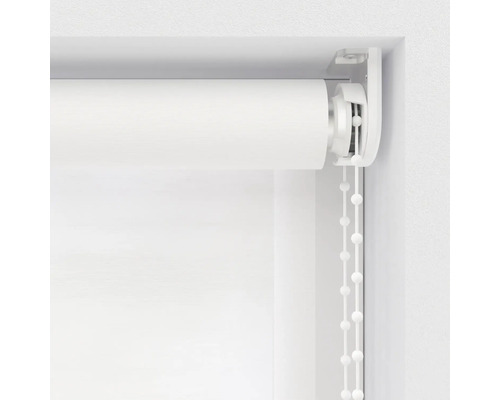 Detaljbild av en vit rullgardin med kedjedrag i fönsterkarmen.