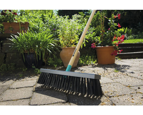 Gardena kvast med träskaft på gatsten i trädgården