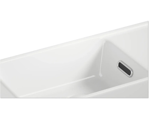 Detaljvy av ett tvättställ i keramik med överfyllnadsskydd