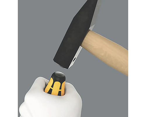 En hammare slår på en skruvmejsel i en hand