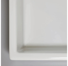 Detaljbild av en rektangulär, platt keramisk tvättställ