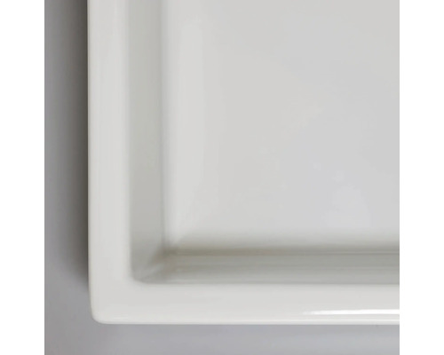 Detaljbild av en rektangulär, platt keramisk tvättställ