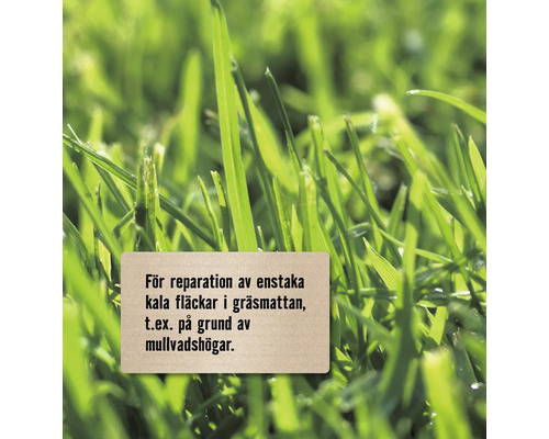 Närbild av gräs med en skylt för reparation av enstaka kala fläckar i gräsmattan, till exempel på grund av mullvadshögar.