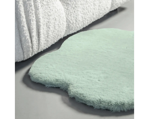 Dekorativ matta i ovanlig form bredvid en textil