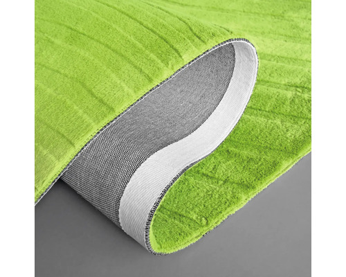 Närbild av en grön matta med en rullad kant som visar undersidan