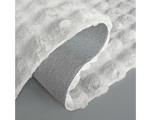 Detaljvy av en matta med noppstruktur och textilbaksida.