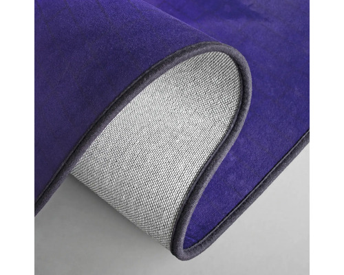 Detaljvy av en lila matta med textilbaksida