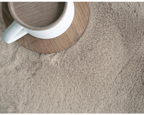 Närbild av en lurvig matta med kopp