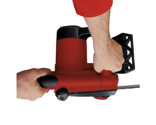 Person som använder en elektrisk motorsåg.