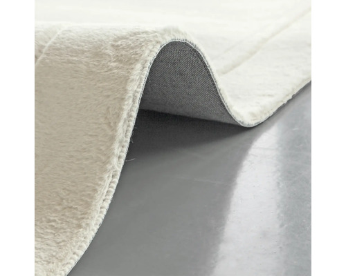 Detaljvy av en ljus matta med lugg och baksida