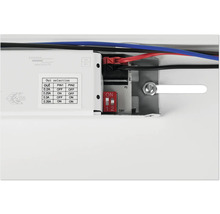Detaljvy av en elektronisk enhet med kablar, omkopplare och en tabell för val av utgång.