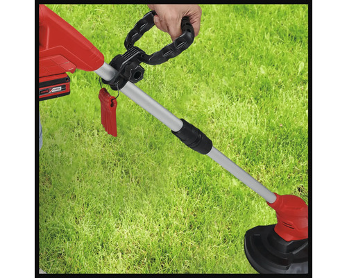 Batteridriven grästrimmer i användning på en gräsmatta.