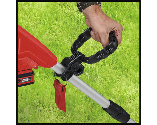Detaljbild av en grästrimmer med en hand på handtaget