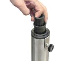 En hand placerar en svart reduceringshylsa på ett metallstativ för ett parasoll.
