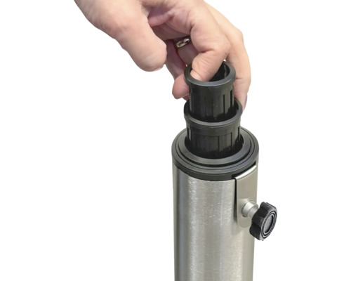 En hand placerar en svart reduceringshylsa på ett metallstativ för ett parasoll.