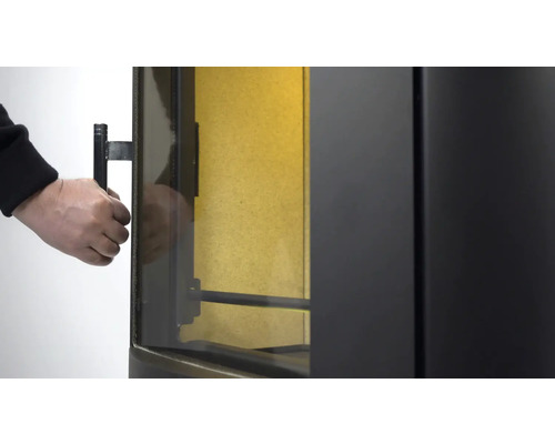 Detaljvy av en vedeldad kamin när dörren öppnas