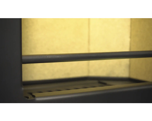 Interiör av en vedeldad kamin med galler och stång