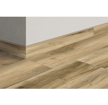 Golvplattor i träutseende med matchande golvsockel på en vägg