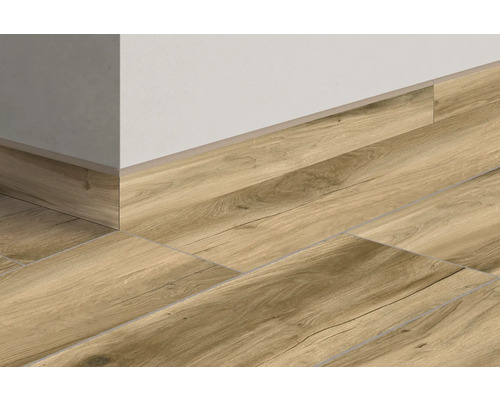 Golvplattor i träutseende med matchande golvsockel på en vägg