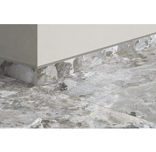 Detaljbild av ett rum med kakel och golvlister i stenimitation