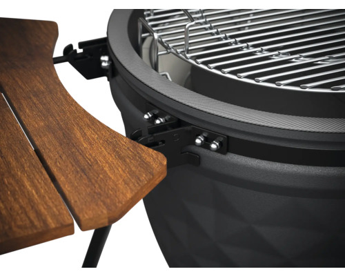 Detaljvy av en klotgrill med träbord