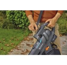 En person fäster en Gardena batteridriven lövsug med axelrem