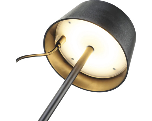 Närbild av en skrivbordslampa med rund fot och lampskärm.