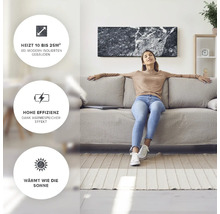 Kvinna kopplar av på en soffa under en marmorvärmare i ett ljust vardagsrum.